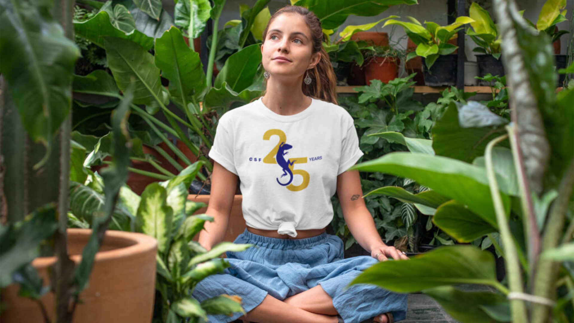 t-shirt-mockup-of-a-relaxed-young-woman-sitting-in-a-greenhouse-27084